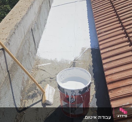 תהליך הלבנת גג ואיטום תעלת ניקוז בציפוי לבן לצד גג רעפים